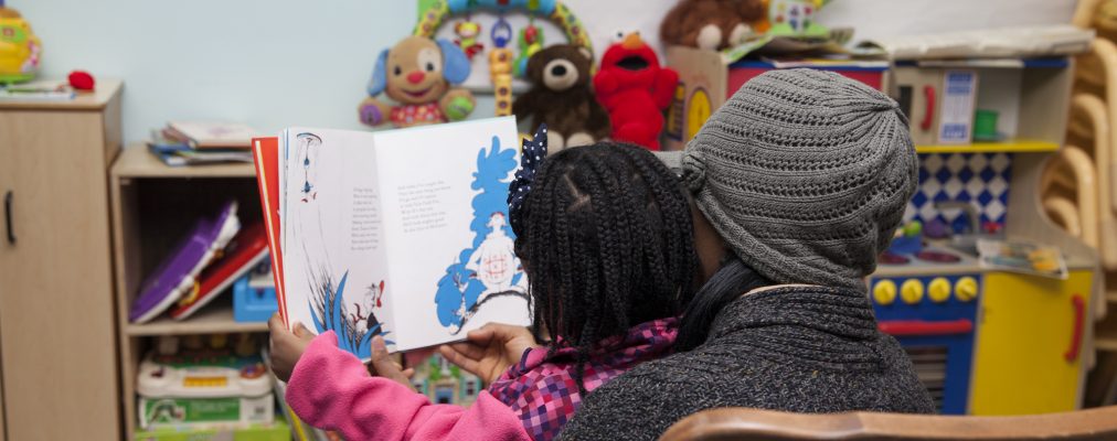 Back of mother and child's head while reading children's book