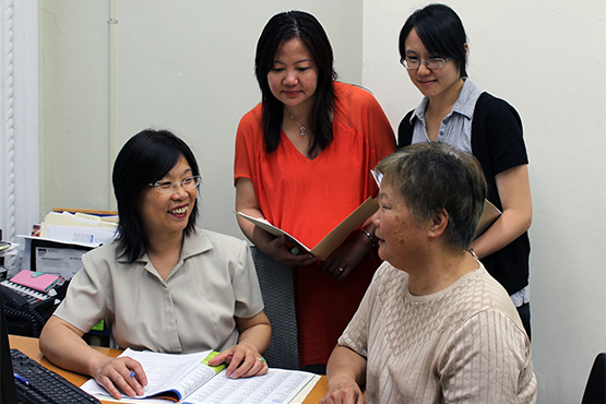 Three women help a client with health care enrollment