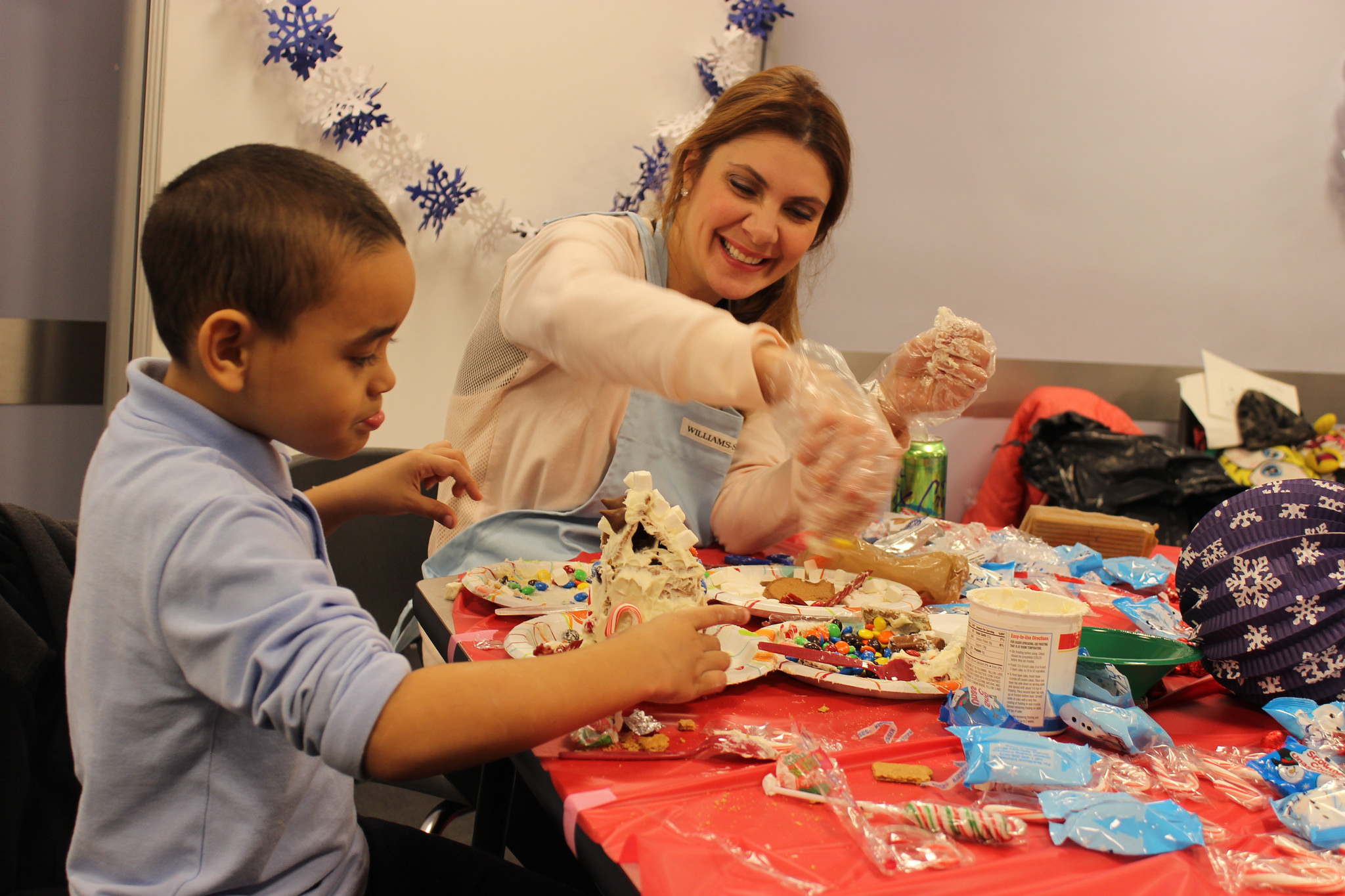 Volunteer makes gingerbread house with child