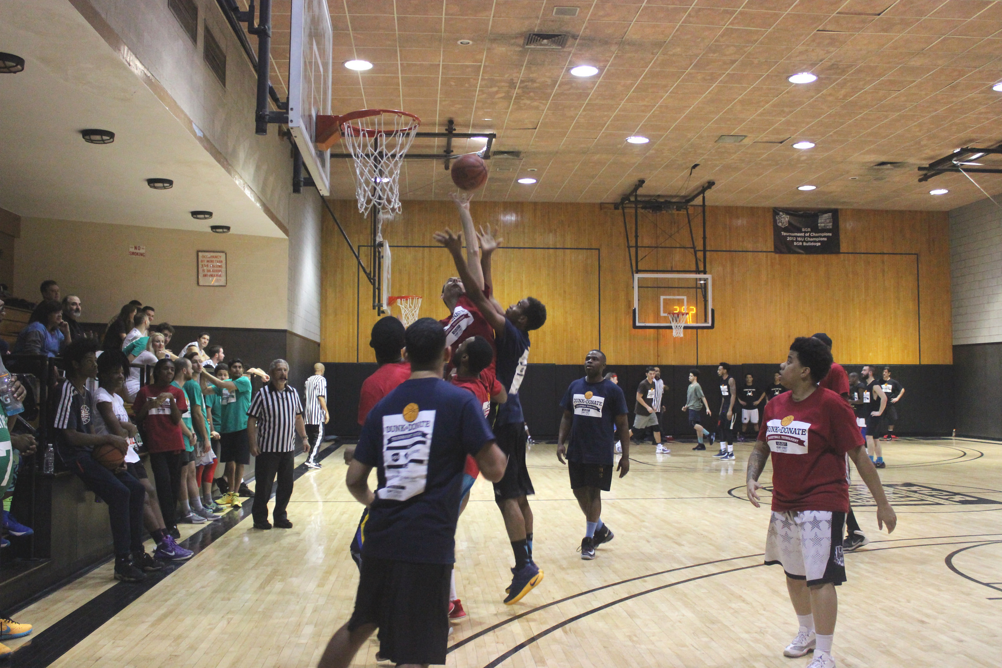 Action shot of men playing basketball from 2017 Dunk & Donate basketball tournament fundraiser