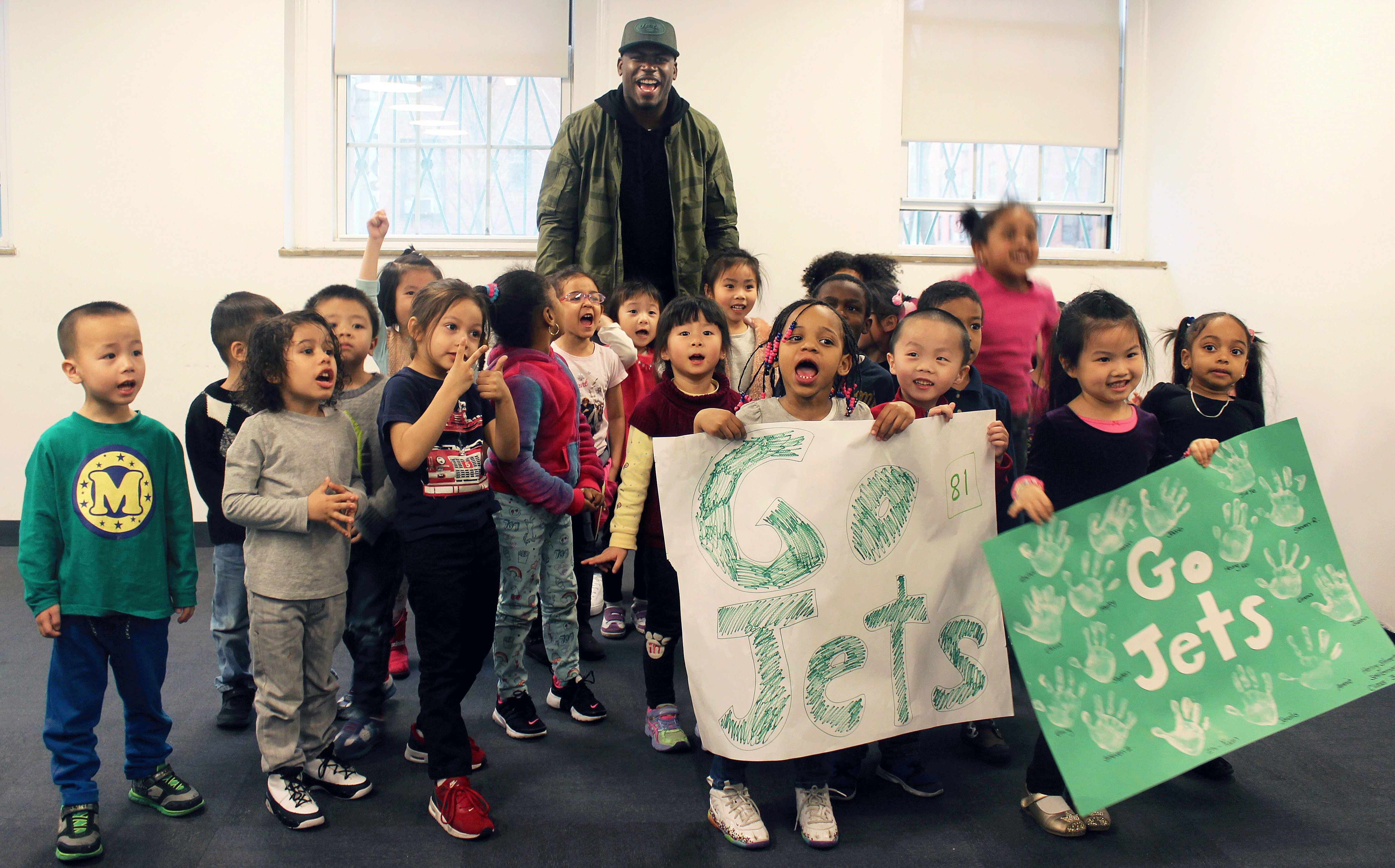 Football player Quincy Enunwa with smiling children from Early Childhood Education