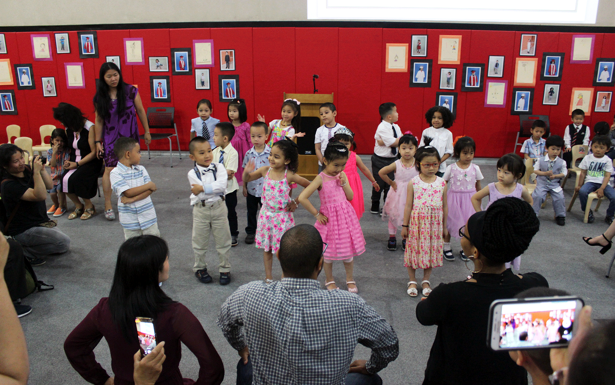 Young children from Early Childhood Education sing while audience watches