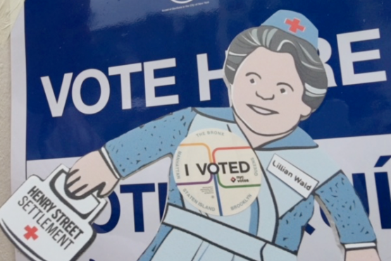 Flat Lillian, a paper doll representation of Henry Street Settlement founder Lillian Wald, outside of a polling location with 'I Voted' button