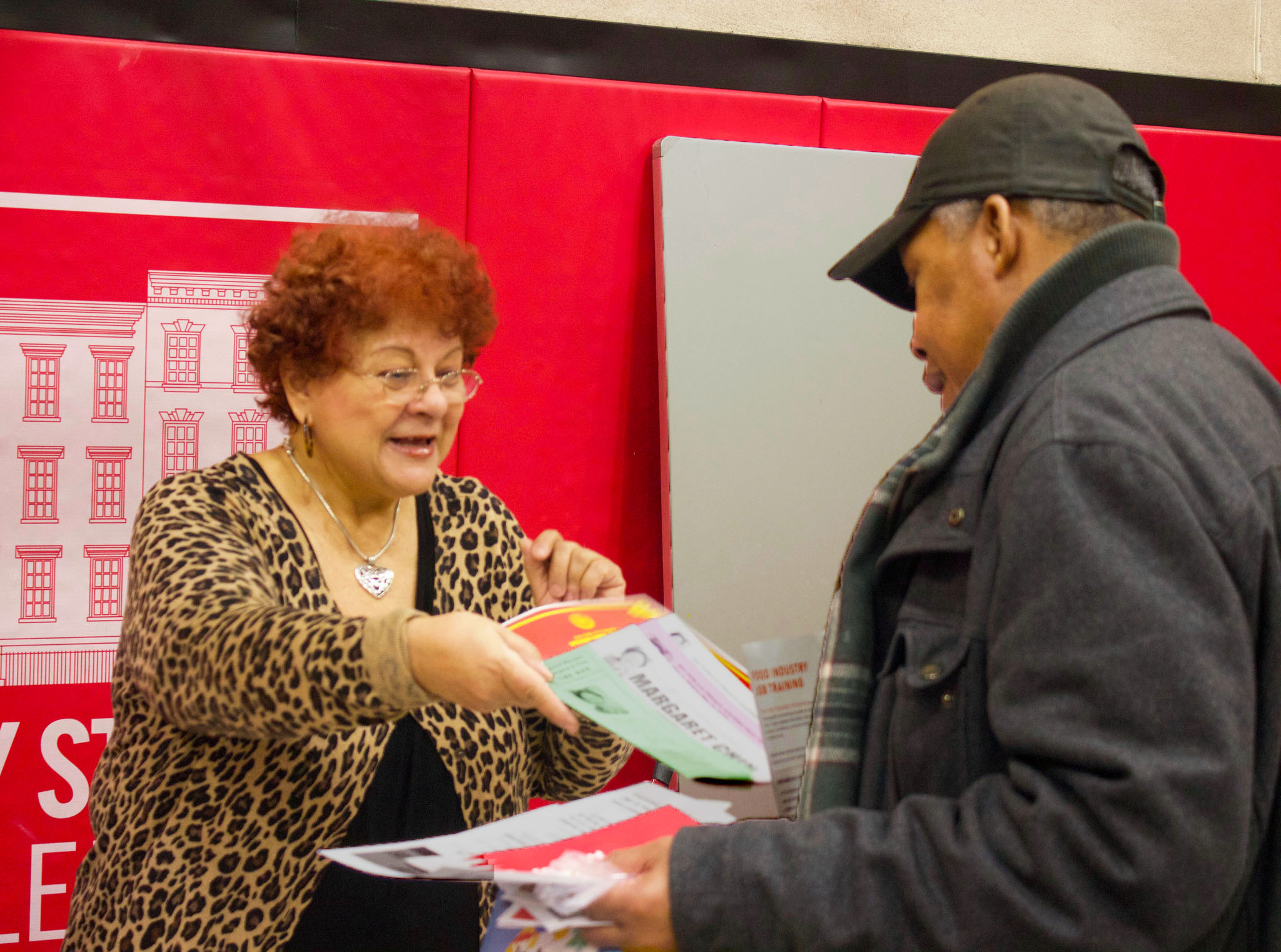 Woman gives man information paperwork at Town Hall event