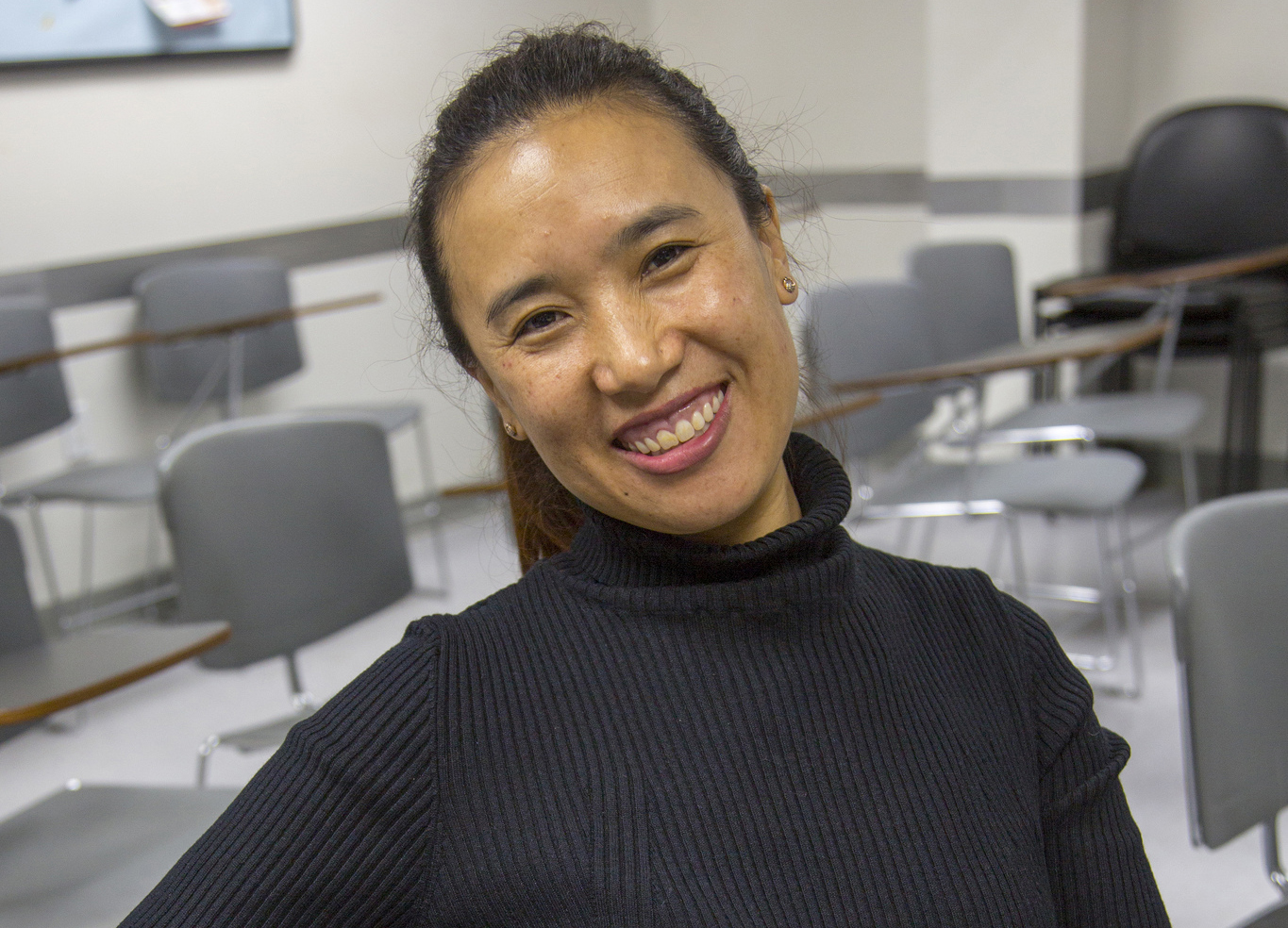 Smiling photo of woman in empty classroom