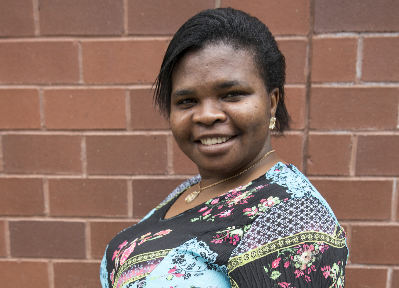 Smiling photo of woman in front of brick wall