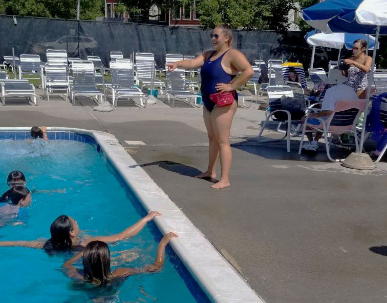 Lifeguard talking to swimmers in pool