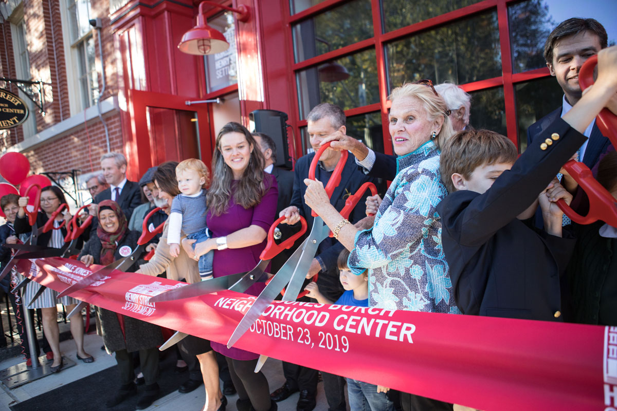 Large multigenerational group at ribbon cutting of new building