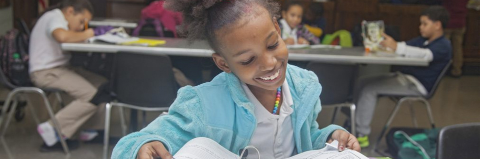 Young girl looks at notebook