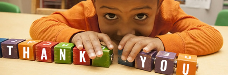 Child with blocks that spell out 'Thank You'