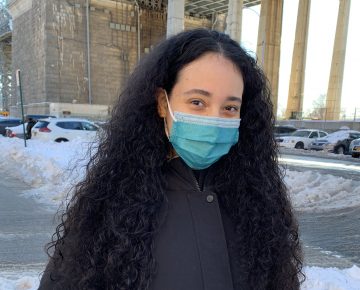 Woman smiles at camera in face mask