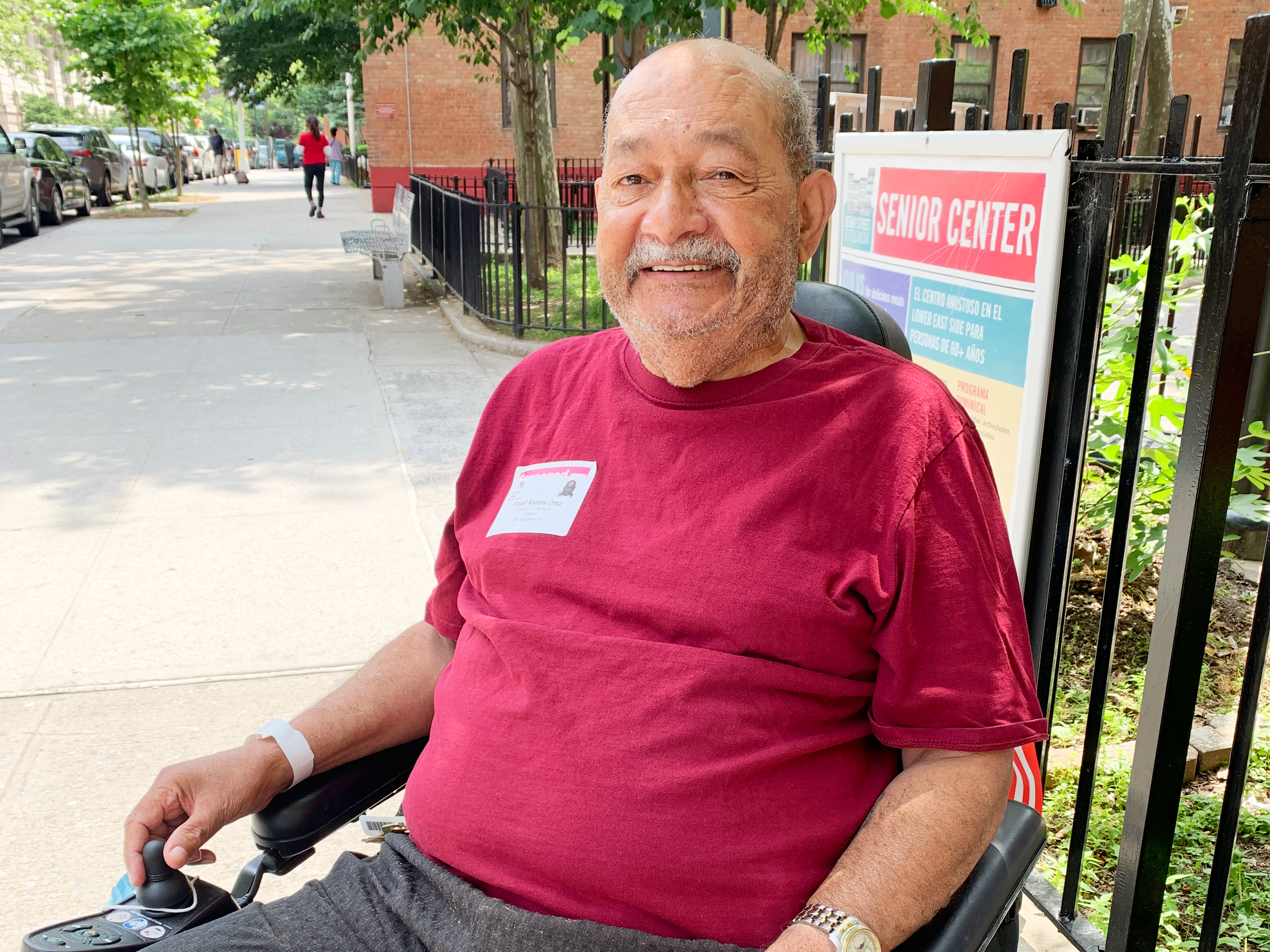 Man in wheelchair smiles in front of Older Adult Center