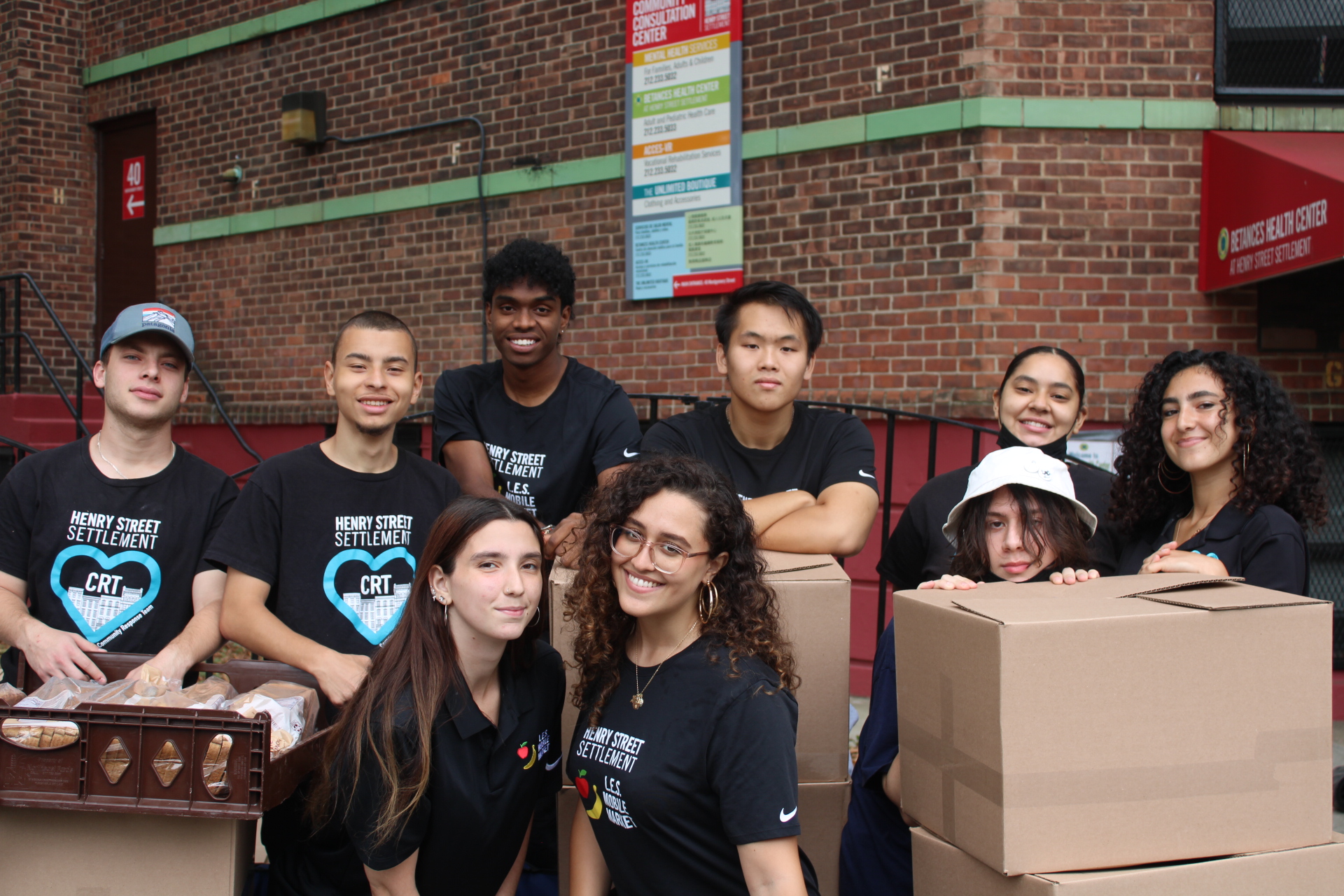 Community Response Team menmbers smile in front of apartment building