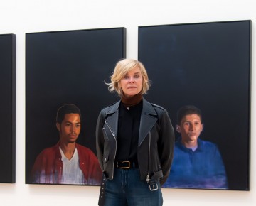 Kate Capshaw stands in front of paintings from the 