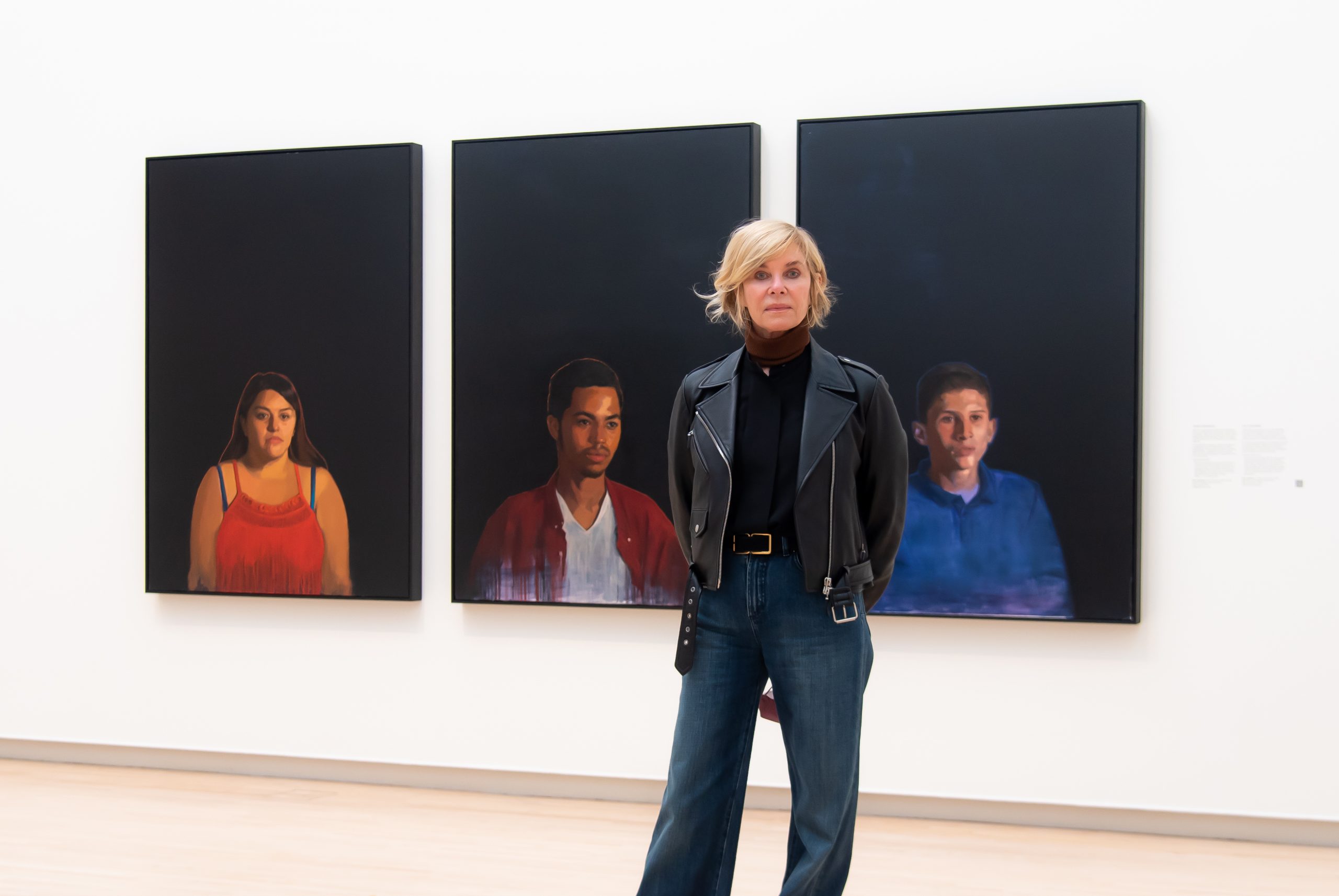 Kate Capshaw stands in front of paintings from the "Unaccompanied" series