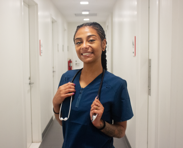 Bianca Pimentel dressed in her work scrubs and holding a stethoscope