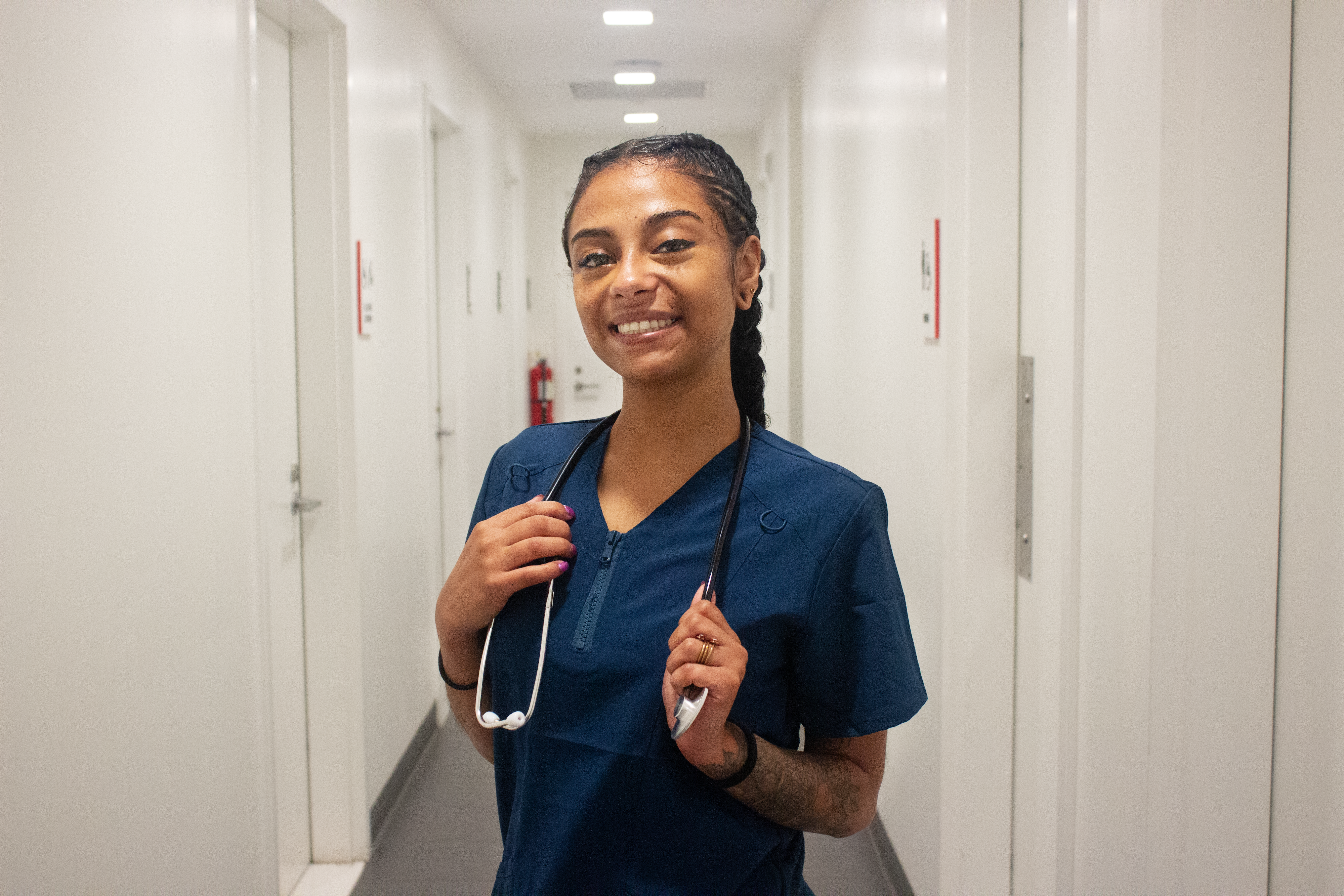 Bianca Pimentel dressed in her work scrubs and holding a stethoscope